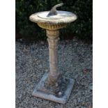 A RECONSTITUTED STONE CIRCULAR SUNDIAL with lead sundial plate and square section spreading base,
