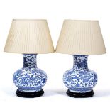 A PAIR OF TABLE LAMPS in the form of Oriental blue and white vases, each decorated with wrythen