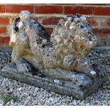 A WEATHERED COMPOSITE STONE STATUE OF A LION pouncing on a ram, 62cm wide x 29cm deep x 42cm high
