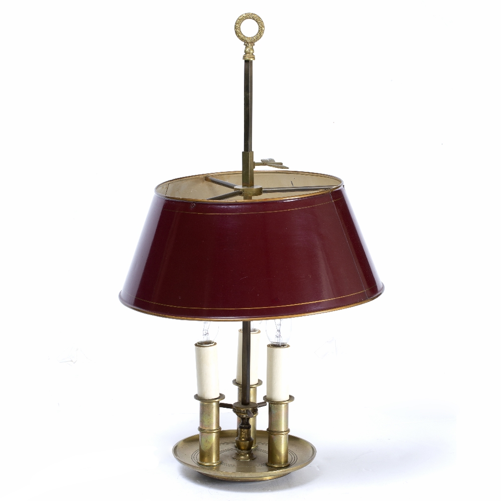 A FRENCH BOUILLOTTE BRASS TABLE LAMP with red painted tin shade and three lights on the dished base,