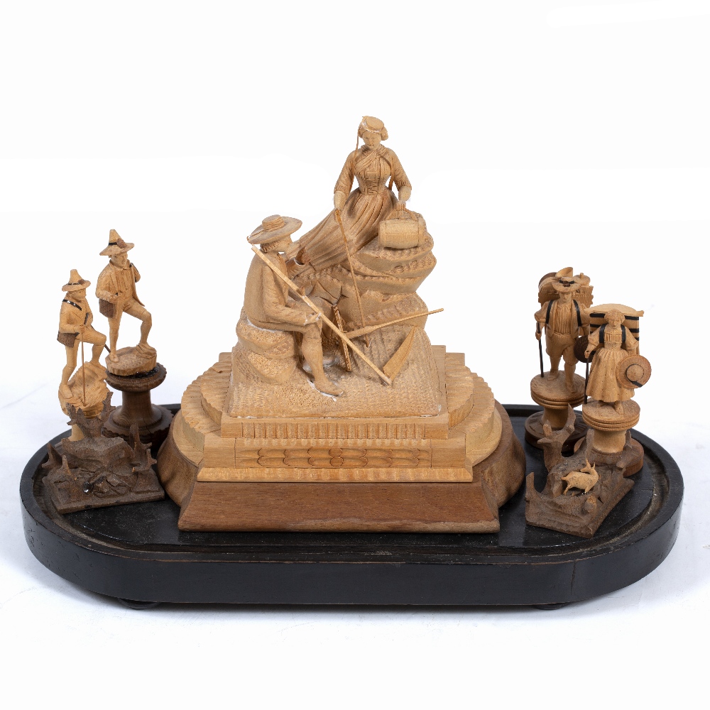 A 19TH CENTURY BLACK FOREST CARVED LIMEWOOD SCULPTURE depicting a mower and his belle resting on a