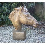 A CAST RECONSTITUTED STONE SCULPTURE OF A HORSE'S HEAD on a plinth base, 59cm wide x 62cm high