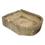 A LARGE CARVED LIMESTONE TROUGH with bowed front and notches cut to the back, approximately 92cm