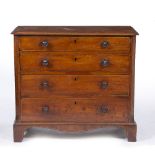 A GEORGIAN MAHOGANY CHEST of four long graduated drawers with turned knob handles and canted