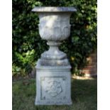 A CAST RECONSTITUTED STONE URN of classical form with acanthus leaf moulded decoration and on a
