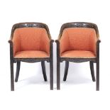 A PAIR OF OAK FRAMED CHAIRS with carved scrolling decoration and orange upholstered back and seat,