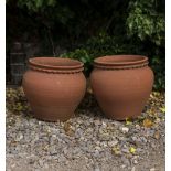 TWO TERRACOTTA PLANT POTS of baluster form, 34cm diameter x 32cm high; a further terracotta type