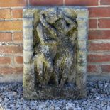 A WEATHERED CAST COMPOSITE STONE PANEL after an Indian original depicting two figures between ringed