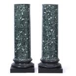 A PAIR OF COMPOSITE PLINTHS of classical column form, decorated to represent green marble, each 44cm