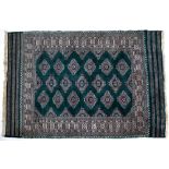 A LATE 20TH CENTURY / EARLY 21ST CENTURY MIDDLE EASTERN RED GROUND WOOLEN RUG with a geometric
