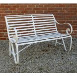 A WHITE PAINTED WROUGHT IRON GARDEN SEAT with scrolling arms, 121cm wide x 72cm deep x 86cm high