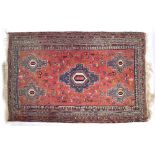 A POSSIBLY NORTH AFRICAN RED GROUND FLAT WEAVE RUG with a multiple banded border having geometric