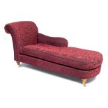 A CONTEMPORARY FLORAL RED UPHOLSTERED CHAISE LONGUE with turned feet and brass castors, 175cm wide x