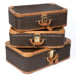 A GROUP OF THREE LOUIS VUITTON LEATHER MOUNTED SUITCASES the largest 80cm wide x 52cm deep x 27cm