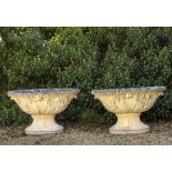 A PAIR OF LARGE OVAL CAST RECONSTITUTED STONE GARDEN URNS with acanthus leaf moulded sides and