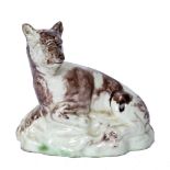 A LATE 18TH CENTURY STAFFORDSHIRE MOULDED POTTERY FIGURE OF A LIONESS resting on a rock, 8.5cm