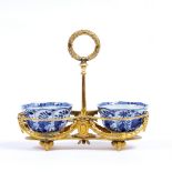 A GILT ORMOLU STAND with laurel wreath moulded central handle, ribbon tied swag decoration and ram's