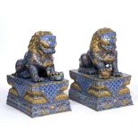 A PAIR OF CHINESE ENAMEL AND BRASS TEMPLE DOGS each on rectangular plinth bases, 43cm wide x 59cm