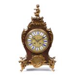 A LATE 19TH CENTURY RED TORTOISE SHELL MANTLE CLOCK with a cherub finial, scrolling gilt mounts