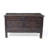 A 17TH CENTURY OAK COFFER with panelled sides and chip carved decoration, 102cm wide x 49cm deep x