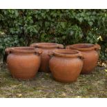 A SET OF FOUR EARLY 20TH CENTURY TERRACOTTA ART NOUVEAU GARDEN POTS with scrolling handles, each