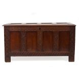 AN OAK 17TH CENTURY FOUR PANELLED CHEST with chip carved decoration to the front, 139cm long x
