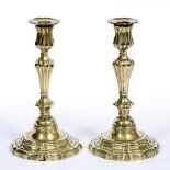 A PAIR OF FRENCH BRASS CANDLESTICKS with shaped bases, 25cm high (2)