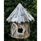 A WOODEN BIRD BOX of cylindrical form with sloping roof, 42cm diameter x 52cm high