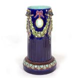 A VICTORIAN MAJOLICA POLYCHROME DECORATED STICK STAND in the form of a classical column with lion