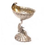 A WHITE METAL LIBATION CUP with shell moulded body and dolphin support, stamped 925 sterling