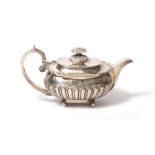 A GEORGE III SILVER TEAPOT with gadrooned body, scrolling handle and marks for London 1809 and