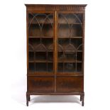 A 19TH CENTURY MAHOGANY BOOKCASE with twin glazed doors and six square tapering legs,158cm wide x