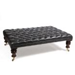 A LARGE BLACK LEATHER BUTTON UPHOLSTERED COUNTRY HOUSE STOOL with turned mahogany legs and brass