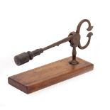 AN EARLY 19TH CENTURY SUGAR NIPPER with a turned ebony handle and mounted on a mahogany base, 35cm