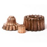 THREE ANTIQUE COPPER JELLY MOULDS the largest 16cm diameter x 9cm high