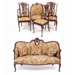 AN EDWARDIAN MAHOGANY SALON SUITE consisting of a small sofa with serpentine front together with