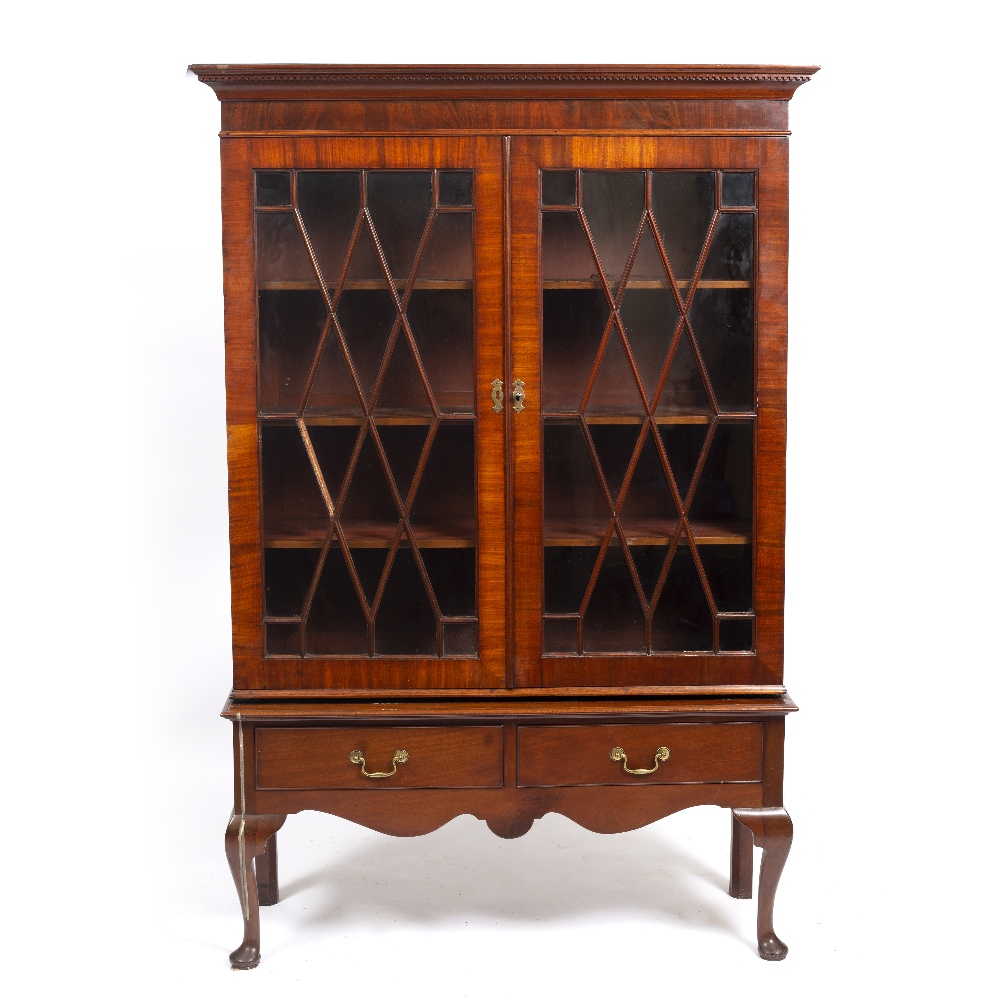 A MAHOGANY BOOKCASE ON STAND with glazed doors enclosing adjustable shelves, the stand with two