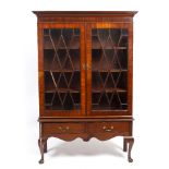 A MAHOGANY BOOKCASE ON STAND with glazed doors enclosing adjustable shelves, the stand with two