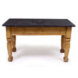 A RECTANGULAR SIDE TABLE with a heavy slate top and a pine base, carved and shaped square legs,