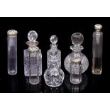FOUR GLASS BOTTLES AND A CUT GLASS ATOMIZER with silver embossed lids with marks for London, four