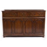 A 19TH CENTURY OAK DRESSER BASE with three drawers, brass swan neck handles and two panelled