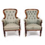 A PAIR OF VICTORIAN WALNUT FRAMED ARMCHAIRS with floral upholstery and button back seats, 97cm