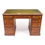 A LATE 19TH / EARLY 20TH CENTURY PITCH PINE AND OAK PEDESTAL DESK with a green leather inset top,