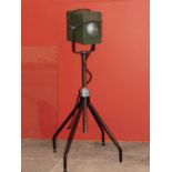 A GREEN PAINTED TIN THEATRE LIGHT on an associated adjustable metal stand, the theatre light 27cm