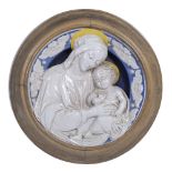 A 19TH CENTURY TIN GLAZED DELLA ROBBIA STYLE CIRCULAR PLAQUE depicting The Virgin and Child, set