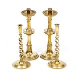 A PAIR OF GOTHIC STYLE BRASS CANDLESTICKS with two further brass candlesticks with barley twist