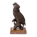 A BRONZE FIGURE OF A COCKATOO with inset green glass eyes, on a carved giltwood and hardstone plinth