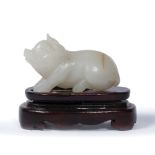 Jade model pig Chinese carved lying down, on a later wooden stand 6.5cm across