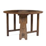 In the manner of Liberty & Co Oak drop leaf table carved to the ends with rose decoration, pegged