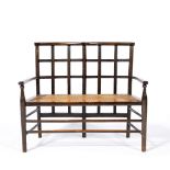 Attributed to Liberty & Co Child's settee, circa 1900 stained wood, lattice back over cane seat